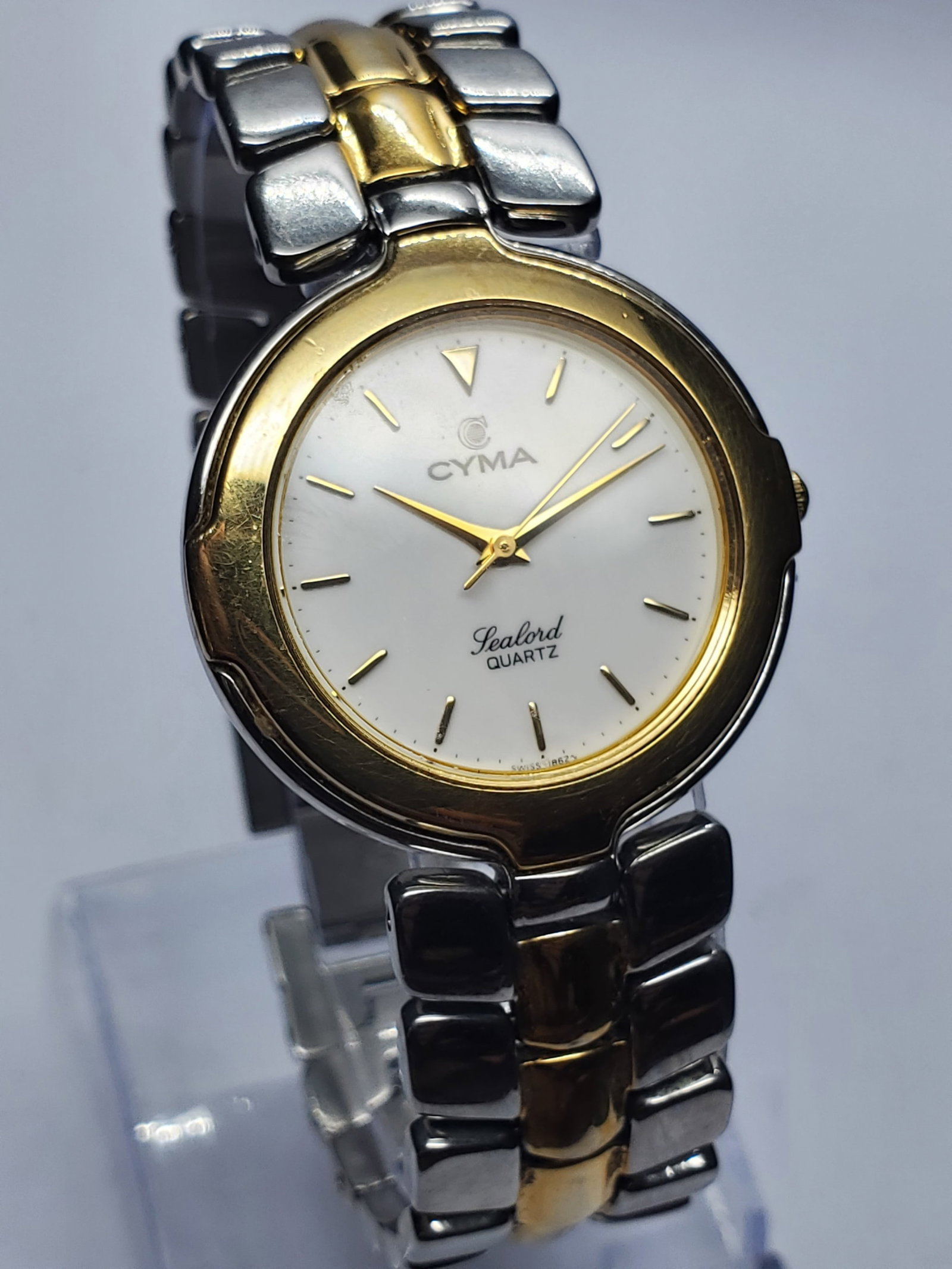 Vintage Cyma Sealord Dual Tone Quartz Swiss Dress Watch, 31mm, 1990s, Running: Experience classic Swiss elegance with this Cyma Sealord Quartz dress watch, a refined timepiece from one of Switzerland?s historic watchmakers. Founded in 1862 in Tavannes, Switzerland, Cyma earned a