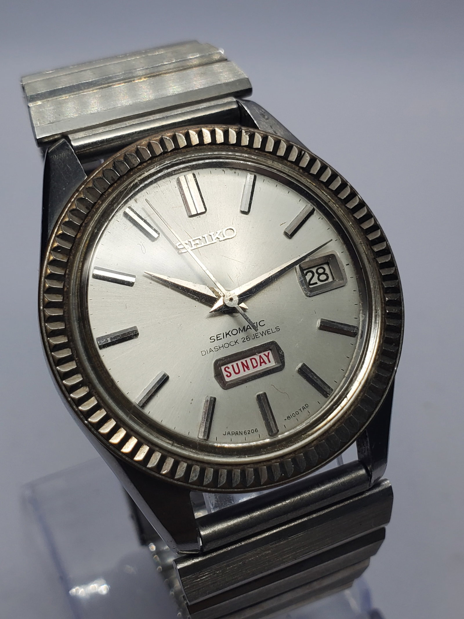 Vintage Seiko Seikomatic 6206-8080 26 Jewels Automatic Watch, 37mm, 1965, Running: Experience the heritage of Japanese watchmaking with this vintage Seiko Seikomatic 6206 8080 automatic dress watch featuring a silver tone case, elegant silver sunburst dial, distinctive day display a