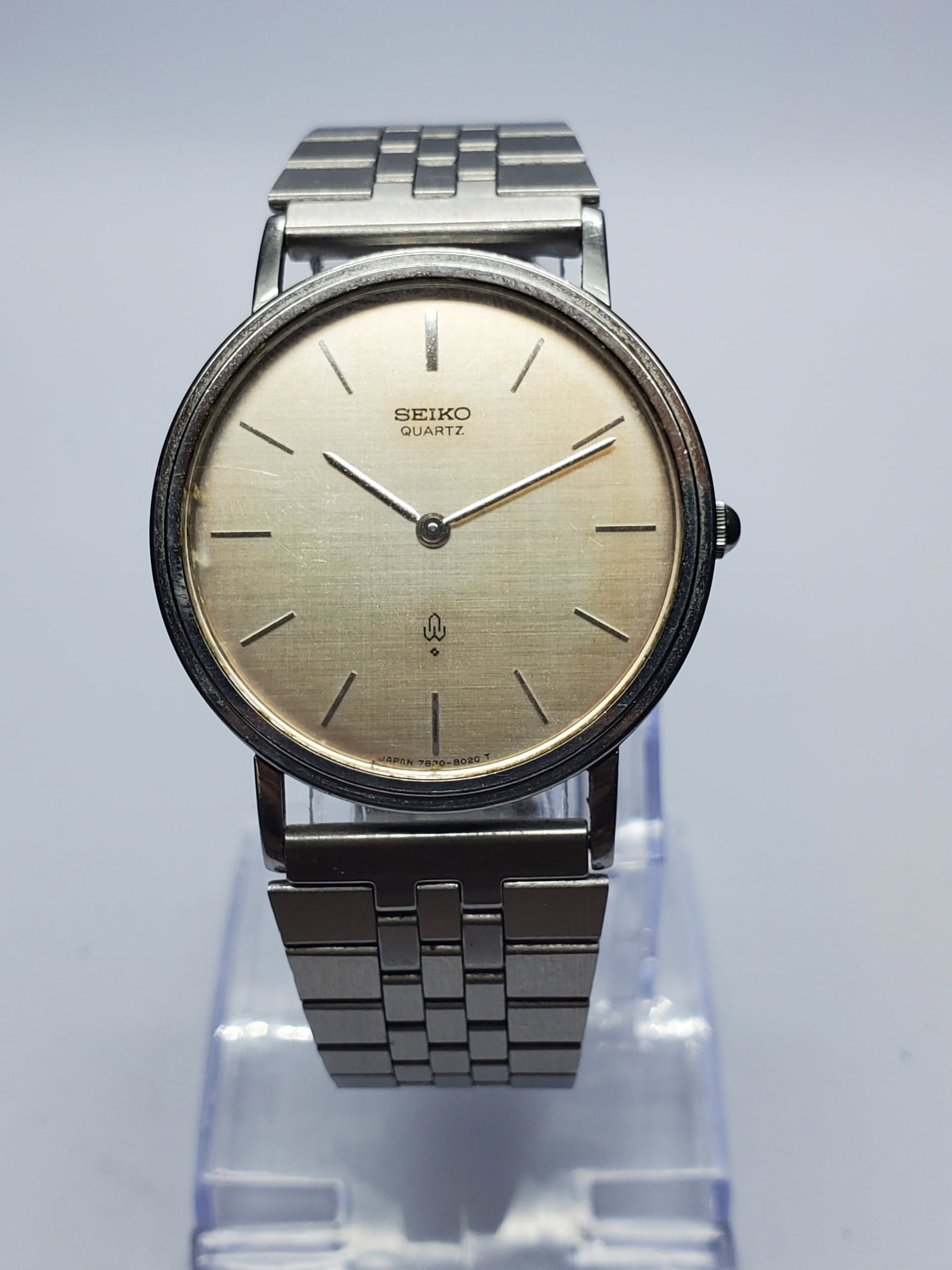 Vintage Seiko 7820-8020 Linen Texture Dial Watch, 33mm, 1979s, Running: Refined and understated, this vintage Seiko 7820-8020 quartz dress watch pairs a 33 mm silver-tone case with a linen-textured silver dial, slim markers, and a metallic bracelet adjustable up to 7.75 i