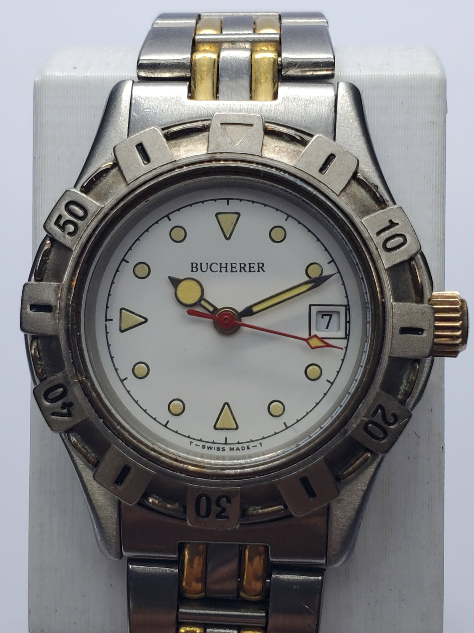 Vintage Bucherer Swiss Quartz Two-Tone Date Watch, 28mm, 1990s, Running: Elegant vintage Bucherer 7.107.0.0 Swiss quartz dress watch featuring a 28 mm silver-tone case, rotating minute bezel, white dial with luminous markers and hands, date window, and a 6.25-inch dual-ton