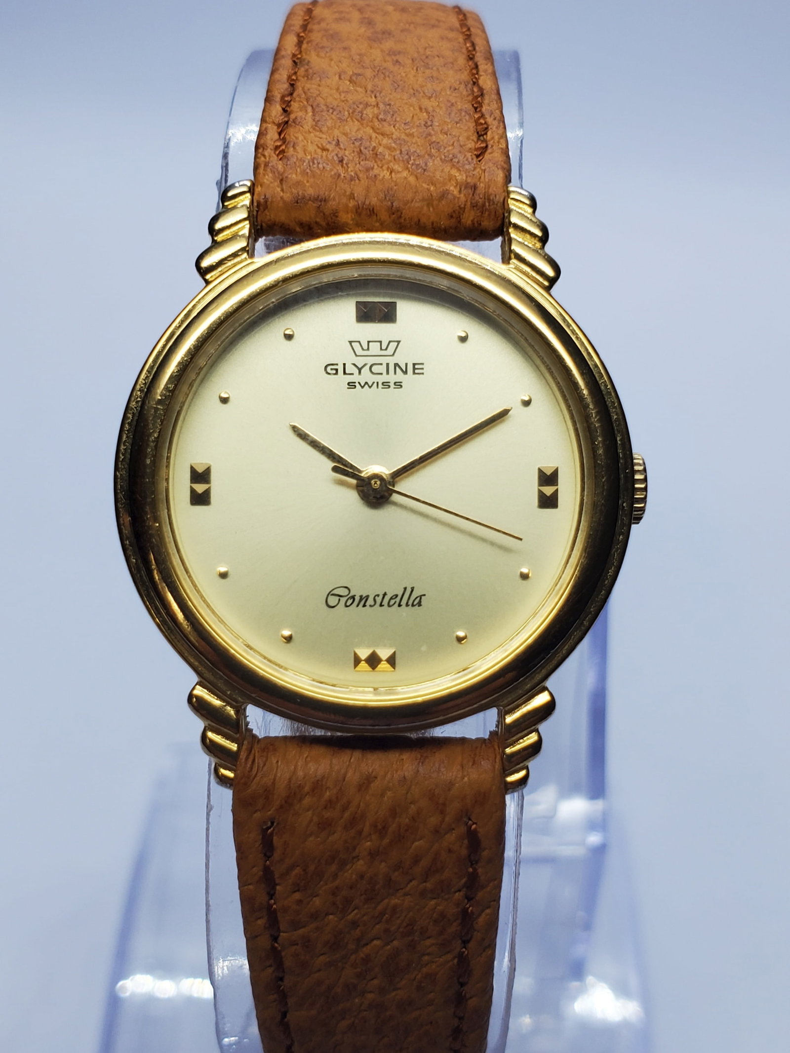 Vintage Glycine Constella Ladies Watch, 23mm, 1990s, Running: Elegant and distinctive, this vintage Glycine Constella ladies? dress watch features a 23 mm gold-plated case, warm gold-tone dial, three-hand quartz display, and 6.75-inch brown leather strap. It is 