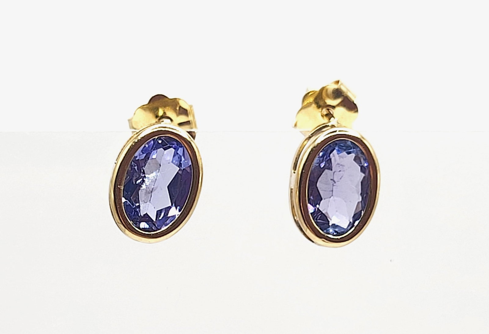 Oval-cut Tanzanite Earrings for Everyday Elegance: Setting: 14K Yellow Gold Main Gemstone: Genuine Tanzanite Closure: Posts and Friction Backs A classic style for everyday beauty! This is a pair of 14 karat yellow gold earrings that feature 1.60 carat