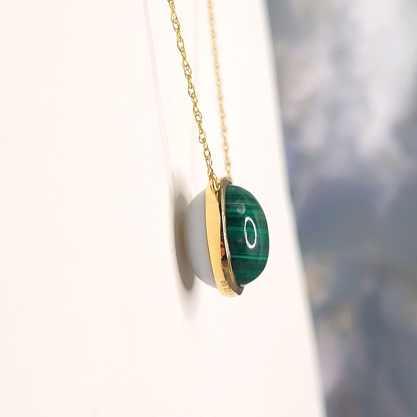 Chic Malachite and White Opal Reversible Necklace: Setting: 18K Yellow Gold Primary Gemstone: Genuine Malachite Secondary Gemstone: Genuine White Opal Link Stye: Fine Cable Link Closure: Spring Ring Length: 18" Adjustable A stylish study in con