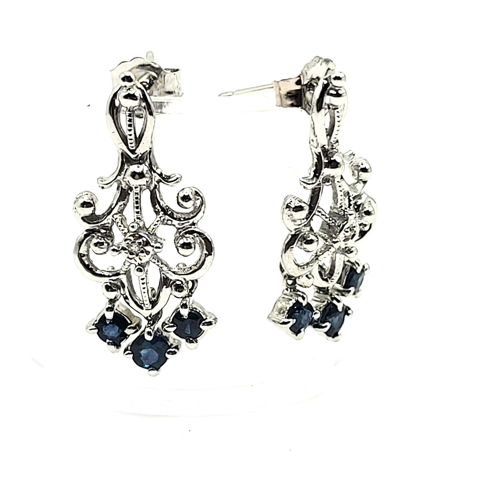 Blue Sapphire Chandelier Earrings Diamond Accent: Setting: 14K White Gold Main Gemstone: Genuine Blue Sapphire Adjacent Gemstone: Genuine, Natural Diamond Closure: Posts and Friction Backs Weight: 3.3g These earrings are a fun match with lots 46, and