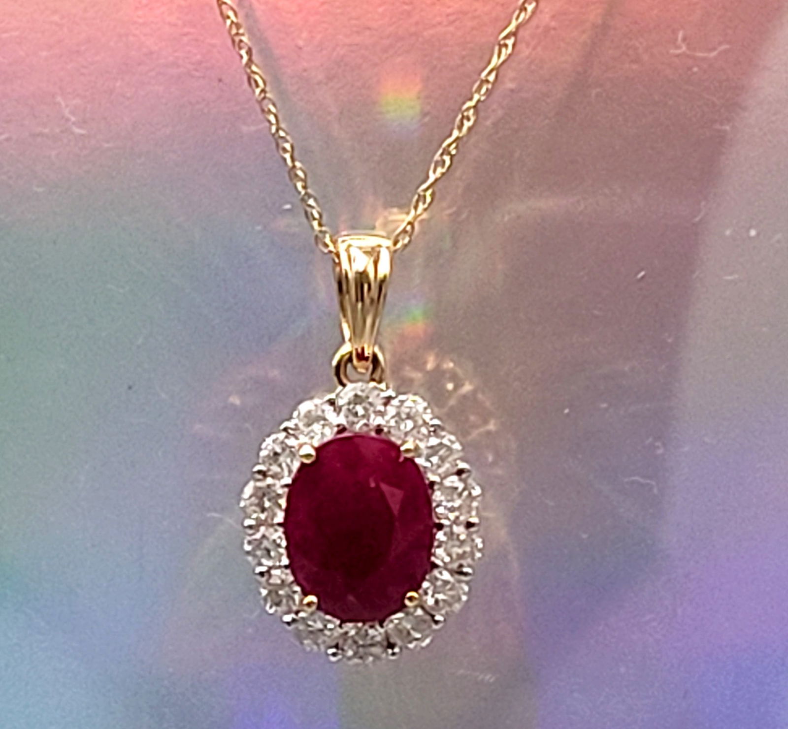2.00 CT Burma Ruby and Diamond Halo Necklace 18K: Setting: 18K Yellow Gold Main Gemstone: Genuine Ruby Gemstone Origin: Burma Adjacent Gemstone: Genuine, Natural Diamond Length: 18" Weight: 3.9 grams This item qualifies for a FREE electronic appraisa