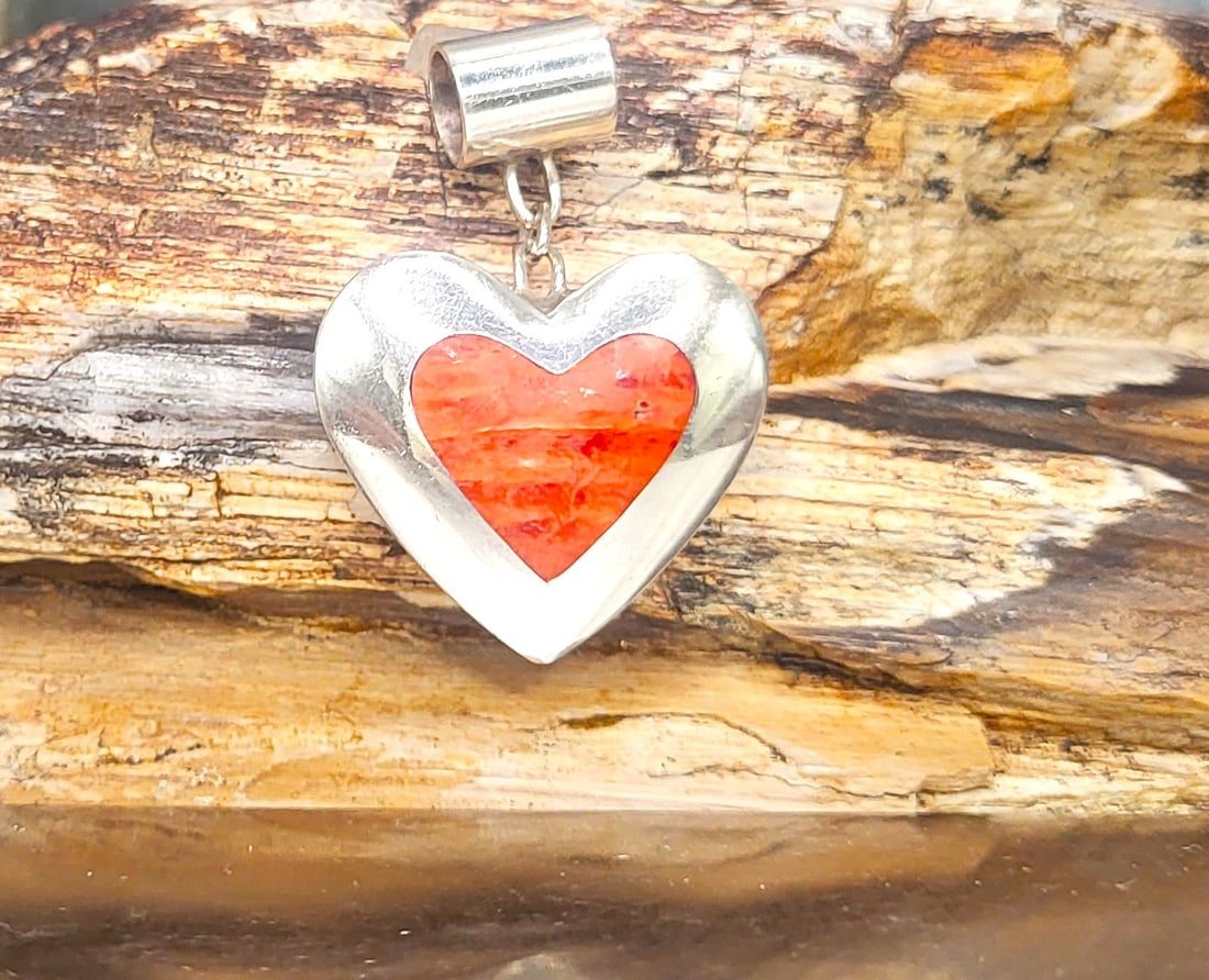 Orange Spiny Oyster Heart Southwest Slide Pendant: Crafted in: Sterling Silver .950 Primary Gemstone: Orange Spiny Oyster Style: Slide/Dangle Circa: 1982 (as per executor of estate) Weight: 9.23g A beautiful piece of orange spiny oyster shell, measuri