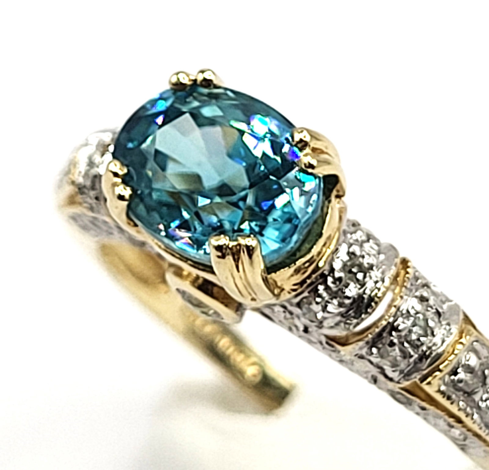 Heavenly Blue Zircon with Teal Overtones Ring with Diamond Shoulders: 100179 Setting: 14K Yellow Gold Main Gemstone: Genuine Blue Zircon Adjacent Gemstone: Genuine, Natural Diamond Size: US 10 Weight: 4.14g This is a 14 karat yellow gold ring that features a gorgeous ov
