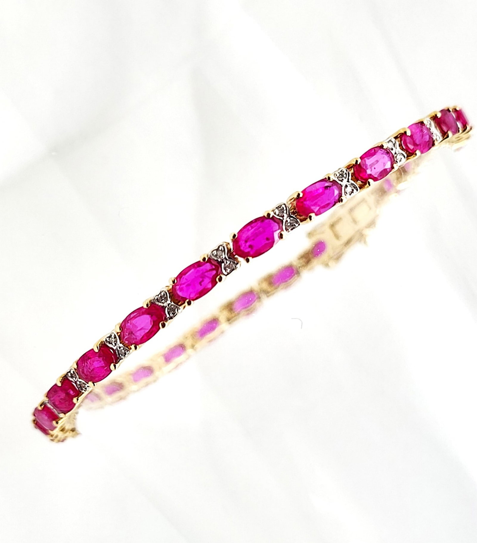 Oval-Cut Ruby Bracelet with Bow-Tie Diamond Accent: Setting: 14K Yellow Gold Main Gemstone: Genuine Ruby Adjacent Gemstone: Genuine, Natural Diamond Length: 7" Weight: 8.72g THE CONSIGNOR REQUIRES A WIRE TRANSFER, ACH, OR ZELLE AS THE ONLY FORMS OF PAY