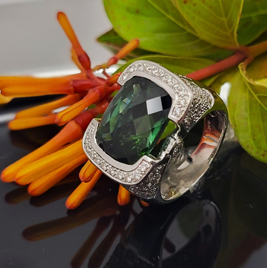 Glamorous Green Tourmaline and Pave Diamond Ring: Setting: 18K White Gold Main Gemstone: Genuine Green Tourmaline (Verdelite) Adjacent Gemstone: Genuine, Natural Diamond Size: 5.75 US Weight: 11.22g This item qualifies for a FREE electronic appraisal