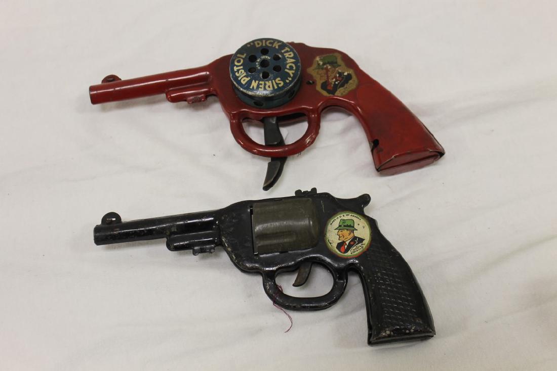 Dick Tracy Siren Pistol and pop gun. Both painted: Dick Tracy Siren Pistol and pop gun. Both painted metal, Siren pistol is 8 3/4" long, marked Made in USA, with some decal wear. Pop gun is 7 3/4"