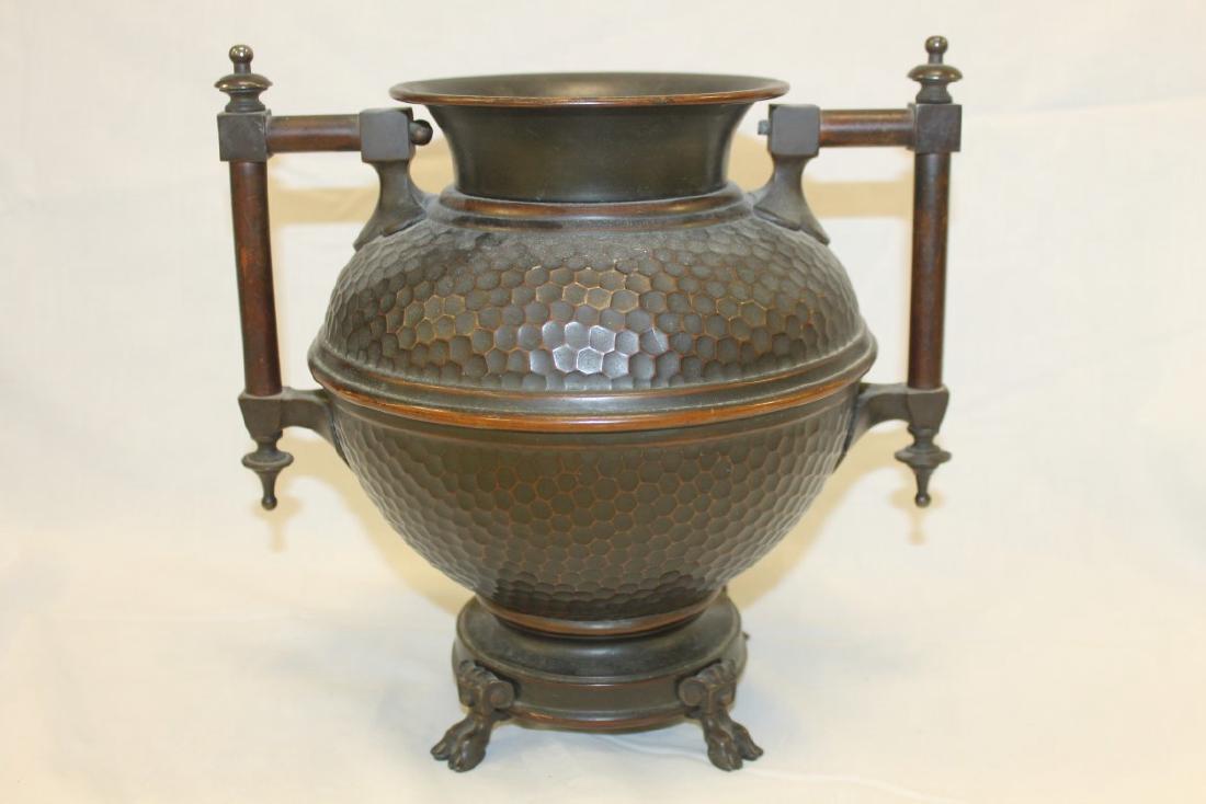 Hammered bronze 2-handle urn with honeycomb exterior: Hammered bronze 2-handle urn with honeycomb exterior and double hoof feet. App. 10 1/2" tall and wide at handles.