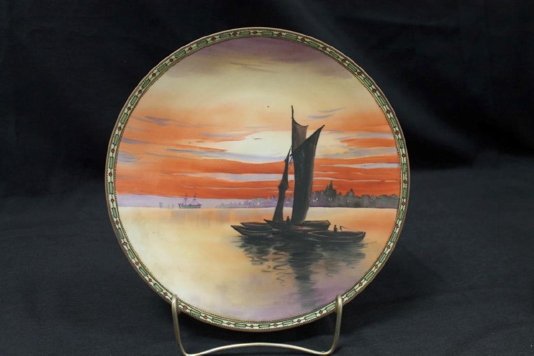 Nippon Green M in wreath 10" plate with enamel line and: Nippon Green M in wreath 10" plate with enamel line and beaded border with sunset scene of a masted boat with 3 ships, plus a commercial ship and a City in the background