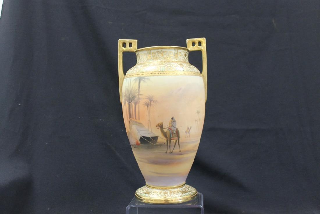 Unmarked Nippon Man on Camel 13 1/2" 2-handle vase with: Unmarked Nippon Man on Camel 13 1/2" 2-handle vase with gold decoration. Minor wear, drill hole in base has been professionally filled.