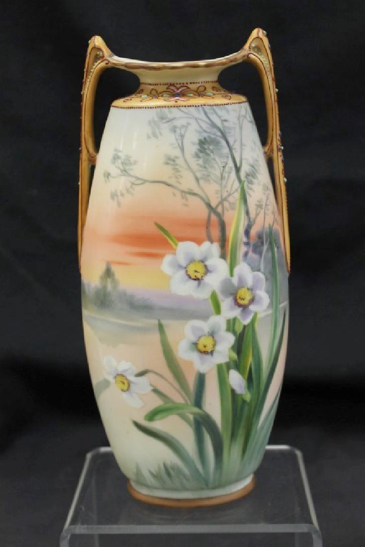 Nippon Green M in wreath 10" bisque scenic vase with: Nippon Green M in wreath 10" bisque scenic vase with daffodils. Bead missing on handle.