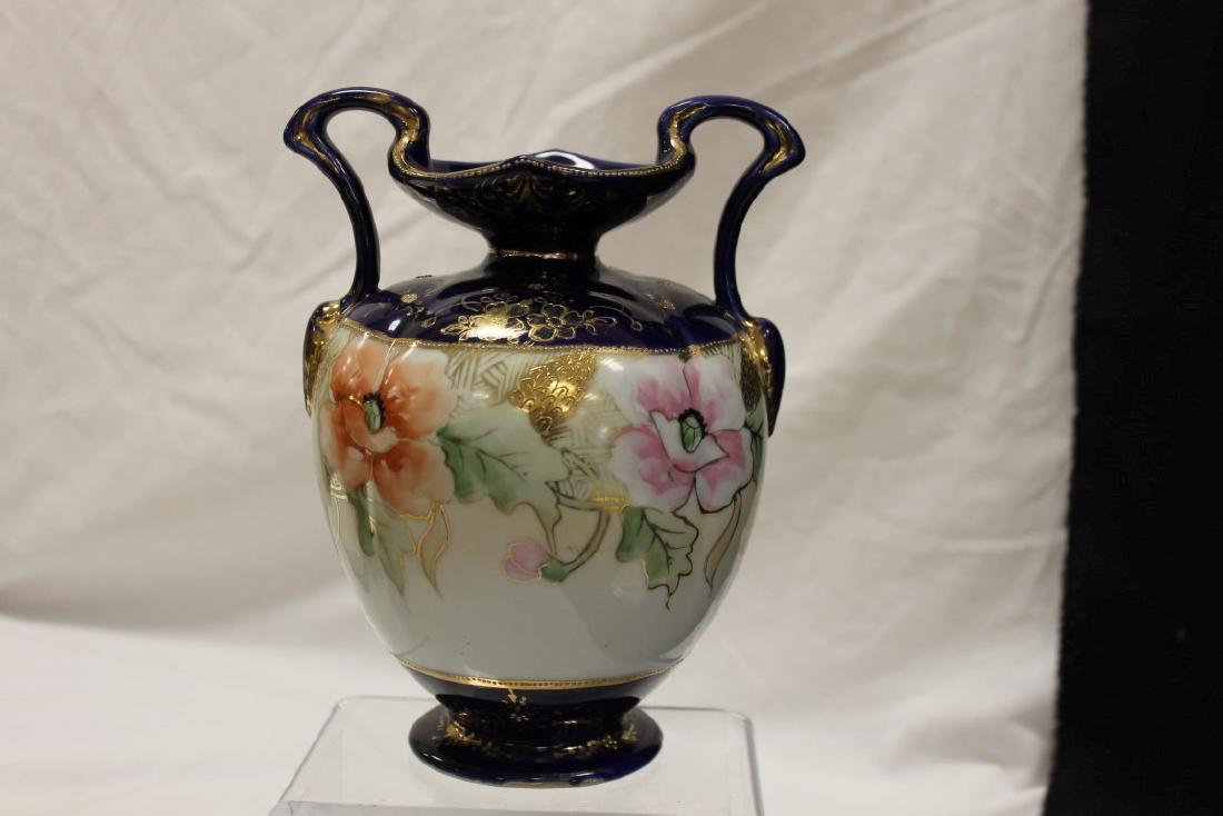 Nippon Blue M in wreath cobalt banded 2-handle vase: Nippon Blue M in wreath cobalt banded 2-handle vase with beaded gold and floral decoration, with a center band of poppies and gold pinecones.
