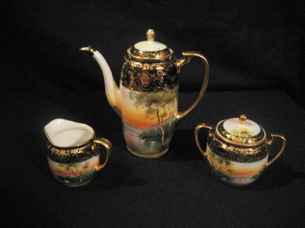 Nippon Green M with wreath 3-piece tea set with coba: Nippon Green M with wreath 3-piece tea set with cobalt and gold decoration with swan and bridge scene. Minor nick on spout of teapot.