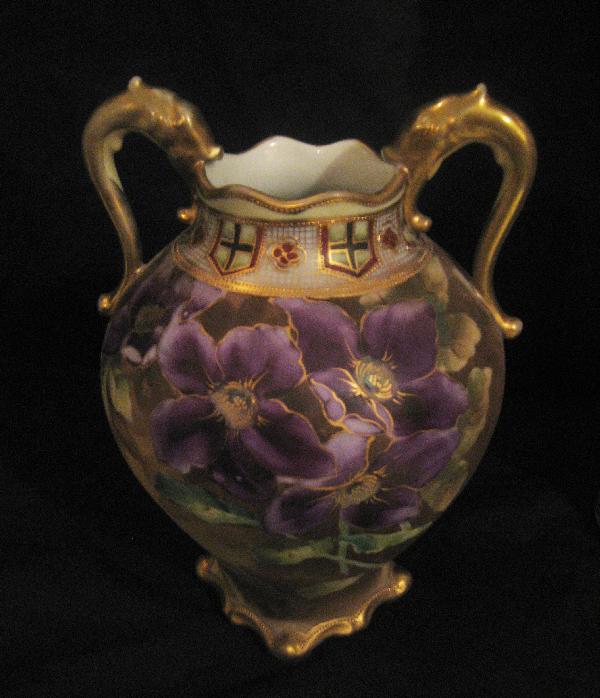 Nippon Green M with wreath 9" satin finish 2-handle: Nippon Green M with wreath 9" satin finish 2-handle vase with purple flowers and gold serpeant handles. Minor gold wear on handles and rim.