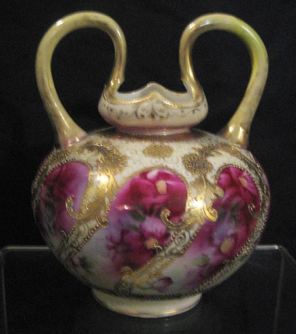 Nippon Green maple leaf 7 3/4" loop handle vase: Nippon Green maple leaf 7 3/4" loop handle vase with swirl floral windows and gold decoration. Gold loss on handle and rim.