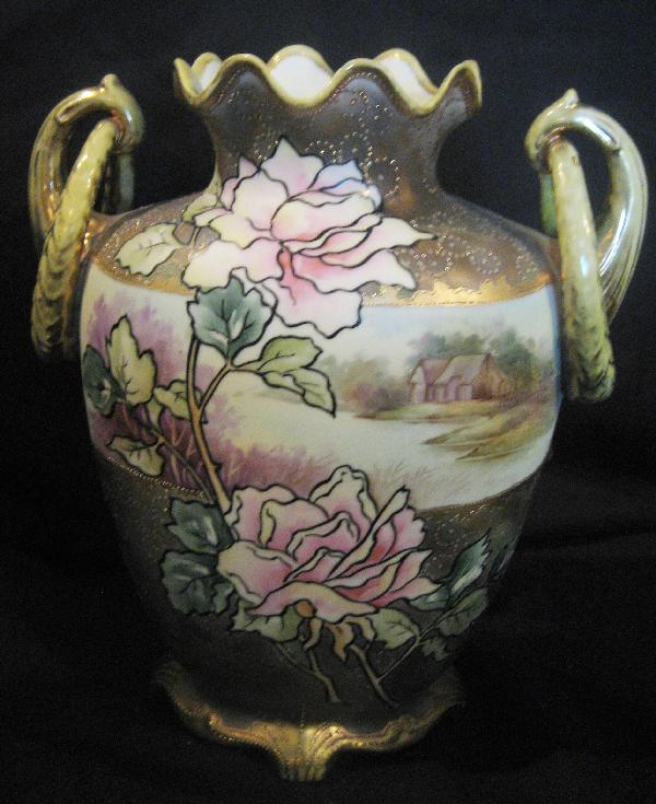 Nippon Blue maple leaf 11 3/4" loop handle vase: Nippon Blue maple leaf 11 3/4" loop handle ruffle top vase with landscape scene, gold wash ground, with outlined gold overlay and enamel beading. Gold loss on rim and handles.