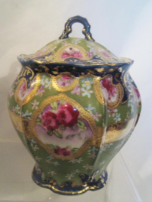 Unmarked Nippon cobalt and rose decorated cracker: Unmarked Nippon cobalt and rose decorated cracker jar with beaded and gold band decoration on a green ground. Crow's foot in base.