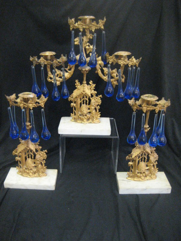 Garniture set depicting bears raiding a beehive.: Garniture set depicting bears raiding a beehive. Incomplete set of cobalt tear drop prisms. Single sticks are 12 1/4" tall.