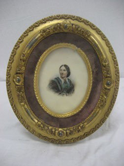 Oval framed portrait on milk glass of a lady.