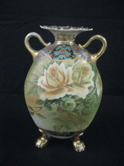 446. Nippon blue M with wreath 10” satin finish ro: Nippon blue M with wreath 10” satin finish rose decorated 2-handle claw foot vase. Some gold wear.