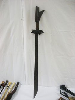 Machete with carved wooden handle and wrapped grip: Machete with carved wooden handle and wrapped grip. 40" overall length, 5 1/4" wide at handle guard.