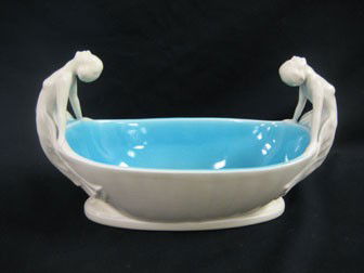 Rookwood 1927 oval centerpiece with semi-nude lady: Rookwood 1927 oval centerpiece with semi-nude lady handles. 13" long, 7 1/2" tall, 6 1/4" wide with blue crysoline glazed interior. Chip and line cracks at hands on lady handle at right. Louise Abel m