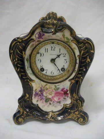 Royal Bonn La Tau cobalt floral decorated clock ca: Royal Bonn La Tau cobalt floral decorated clock case with Ansonia face and works, minor lines on face at center and off right keyhole, enamel loss on edge at 10.