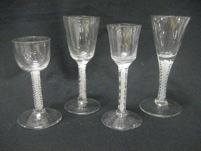 Four (4) drinking glasses, tallest is 6 1/2", each: Four (4) drinking glasses, tallest is 6 1/2", each stem with multiple opaque threads, two with base chips