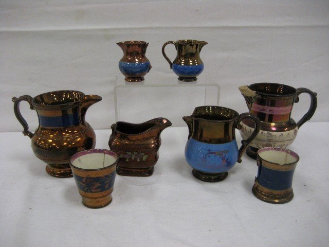 Copper lustre: 5 3/8" pitcher with beading and bl: Copper lustre: 5 3/8" pitcher with beading and blue band; 2 3/4" beaker with blue decorated band, line cracks; (2) damaged creamers with blue bands; enamel decorated creamer with no handle, chip, crac