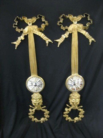 Pair of molded brass wall sconces with satyr head,: Pair of molded brass wall sconces with satyr head, grape leaf and vine border, with bowknot crest and beveled mirrored starburst medallions. 24 1/2" tall.