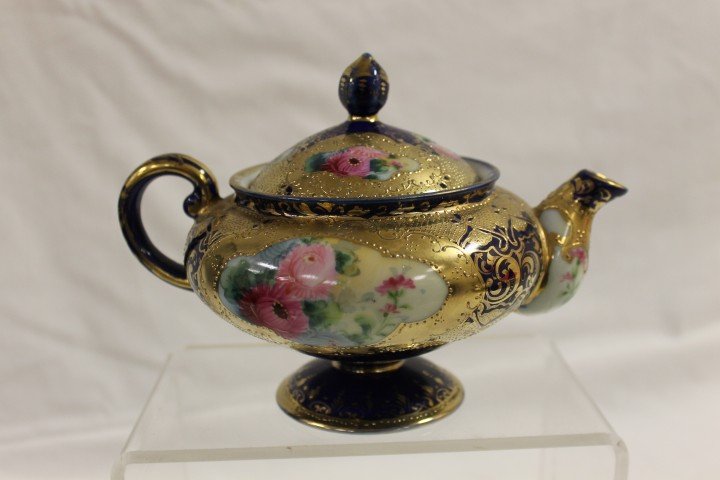 Blue maple leaf Nippon cobalt floral teapot with h: Blue maple leaf Nippon cobalt floral teapot with heavy gold decoration, app. 5" tall, 7 1/2" wide, with minor nick on interior rim. We have found that the handle has been repaired on this teapot