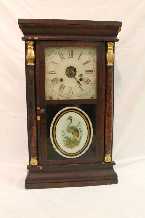 Seth Thomas double decker closk with half columns: Seth Thomas double decker closk with half columns and reverse painting of a plumed bird. Veneer loss, paint loss on metal face, 14 3/4" wide, 25" tall