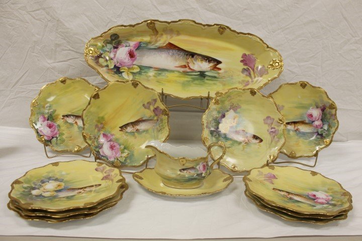 Limoges Coronet fish set decorated with roses: Limoges Coronet fish set decorated with roses sheltering fish on a yellow background. 24" platter, (10) 9 1/2" plates, 10 3/8" sauce boat with underplate. Minor gold wear. Set is signed by artist Duva