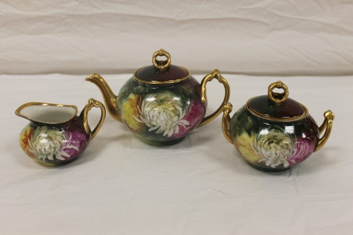 Ravenwood 3 piece tea set decorated with spider mums on: Ravenwood 3 piece tea set decorated with spider mums on one side, pink flowers on the reverse. Gold handles, double ring finials, minor gold wear. W. Guerin Limoges mark covered in gold on base.