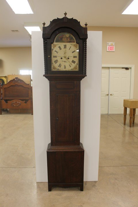 Oak tall case grandfather clock with painted face: Oak tall case grandfather clock with painted face marked John Cruddas Durham. With brass finials and turned nob support columns on hood. Door with ebony line inlay, minor molding loss, app. 89 1/2" ta