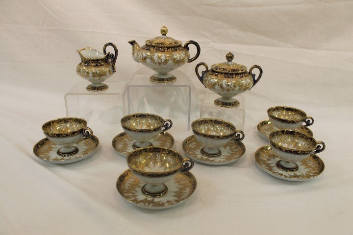 Nippon green maple leaf cobalt and gold decorated tea: Nippon green maple leaf cobalt and gold decorated tea set with (6) pedestal cup and saucer sets, creamer, covered sugar and covered tea pot. Elaborate beaded gold decoration. Repaired rim nick on one