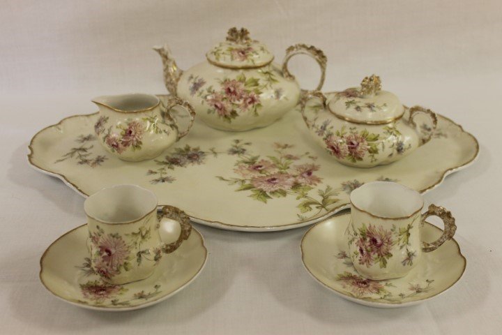 Limoges floral cabaret set with tea pot, creamer,: Limoges floral cabaret set with tea pot, creamer, covered sugar, 19 1/2" tray and two cup and saucer sets. Minor gold wear or loss on handles and finials.