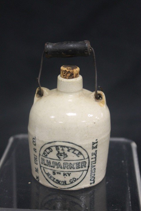 Miniature whiskey jug "R. H. Parker 5th KY Nelson Co.: Miniature whiskey jug "R. H. Parker 5th KY Nelson Co. Old Style N.M. Uri & Co. Louisville, KY" with bail, wooden handle and cork. 3" at top of cork.