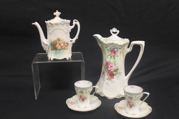 Red mark R.S. Prussia Modl 579 chocolate set with: Red mark R.S. Prussia Modl 579 chocolate set with hanging basket of flowers decoration. Two cup and saucer sets. Pot is app. 9 1/2", minor interior rim nick. Unmarked R.S. Prussia tea pot with basket 