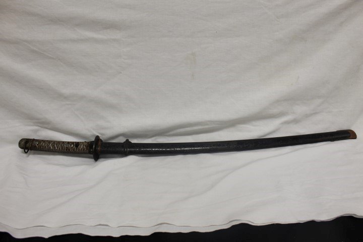 Japanese NCO Katana sword. Blade is bright with some: Japanese NCO Katana sword. Blade is bright with some edge wear and minor nicks. Spring is intact. Numbers on blade and sheath do not match - 67026 on blade, 64061 on sheath. Wear on sheath. 400