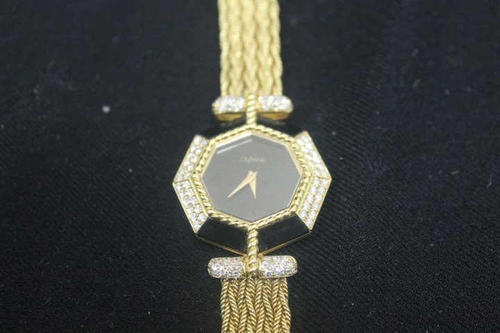 18k yellow gold DeLaneau wrist watch with ebony and: 18k yellow gold DeLaneau wrist watch with ebony and diamond panels. Marked "750 G117 0211AA6" and "750 DeLaneau". Not working. Double safety latches on side. 46.7 g. Provenance: Shirley Firestone Trus