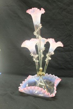 Cranberry epergne with ruffled edge base and four: Cranberry epergne with ruffled edge base and four arms/flutes. Each flute with applied rigaree decoration. App. 19" tall. Center flute is loose in its' holder.