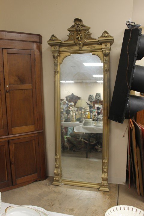 Gilded pier mirror with carved crest. Minor loss on: Gilded pier mirror with carved crest. Minor loss on base and crest.
