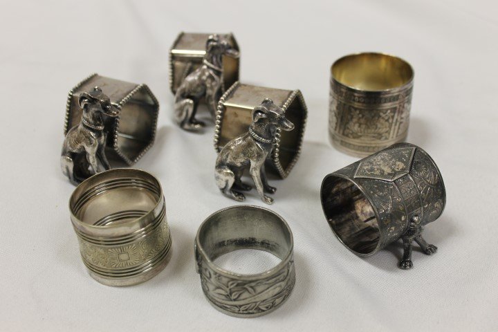 Napkin rings: (3) figural with greyhounds; footed with: Napkin rings: (3) figural with greyhounds; footed with all-over decoration; engraved ringed cylinder "Annie Dec. 1883"; tall with alternating prapes, vine and leaf with bowl with fruit carving; pewter