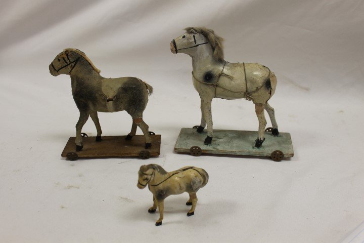 (2) papier mache over wood horse pull toys: (2) papier mache over wood horse pull toys, both with some loss and separation, the largest without a tail, the smaller with no mane hair. Tallest is 7 1/2" and is marked Germany on base. With a well-