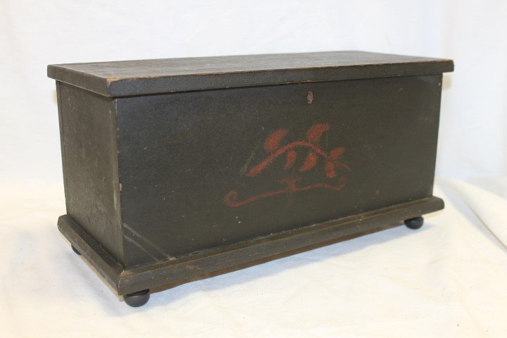 Decorated miniature blanket chest on turned feet with: Decorated miniature blanket chest on turned feet with base molding. Red on black leafy vine decoration, painted on all four sides and on interior and exterior of top. 16 5/8" wide, 7 1/16" deep, 8 7/1