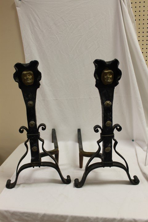 Painted iron and bronze andirons with rolled feet,: Painted iron and bronze andirons with rolled feet, strap iron supports with hammered brass adornments with hooded gilded faces within a molded hood. Possibly monk faces. App. 25" tall, 13 1/4" wide, 2
